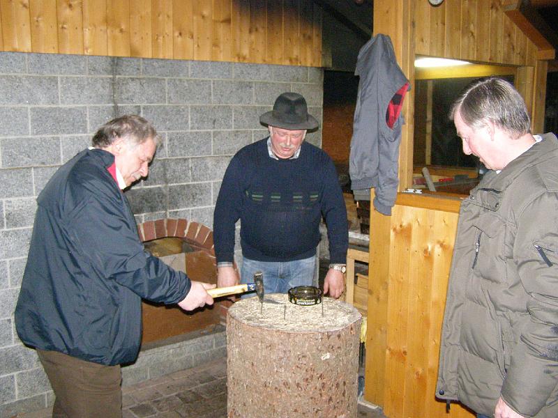 Schalob_02.JPG - Vor der Jahresabschlussfeier im Pass-Stüberl lädt der Wirt (Bildmitte) zum Nageln ein.